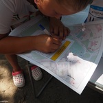 Dziewczynka rozwiązująca zadanie z gry terenowej, zbliżenie na mapę