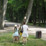 Dziewczynka z mamą biorąca udział w grze terenowej, odczytuje wskazówki na drzewie