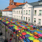 Mieszkańcy spacerują pod kolorowymi parasolami