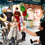 Grupka dzieci z rodzicami biorąca udział w doświadczeniu z balonami i suszarką