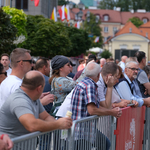 Mieszkańcy Białegostoku obserwujący obchody rocznicy Bitwy Białostockiej, część osób oparta o barierki, kobieta robiąca zdjęcie telefonem