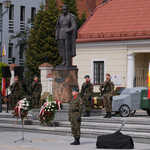 Żołnierze w barwach 18. Pułku Rozpoznawczego stojący na warcie pod pomnikiem Józefa Piłsudskiego, przed nim leżą wieńce, a po bokach stoją flagi Polski