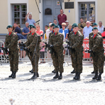 Żołnierze 18. Pułku Rozpoznawczego stojący na placu i oddający salwę honorową,za nimi oddzieleni barierkami mieszkańcy