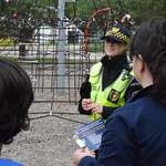 Funkcjonariuszki Straży Miejskiej rozmawiające z kobietą i jej synem na placu zabaw