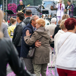 Tańczące i przytulające się starsze małżeństwo, pośród tłumu innych uczestników potańcówki
