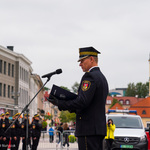 Funkcjonariusz Straży Miejskiej przemawiający do mikrofonu podczas uroczystości