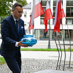 Zastępca Prezydenta Rafał Rudnicki stawia zapalony znicz kwiaty pod pomnikiem bł. ks. Jerzego Popiełuszki