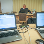 Prezydent Miasta Tadeusz Truskolaski podczas zdalnej sesji Rady Miasta, w pierwszym planie po obu stronach biurka widoczne transmitujące laptopy