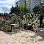 Dzieci bawiące się pod wojskową siatką maskującą