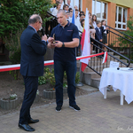 Mężczyzna przekazuje Wojciechowi Nowickiemu statuetkę trenera
