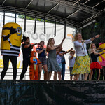 Dzieci tańczące na scenie wraz z dwoma maskotkami Minionków