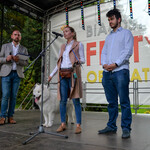Radna Jowita Chudzik przemawia do mikrofonu na scenie z psem