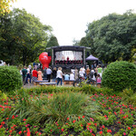 Scena koncertowa w parku wokół której skupieni są mieszkańcy