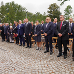 Pierwszy rząd gości honorowych otwarcia Muzeum stoi podczas hymnu