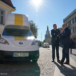 Dyrektor biura ekspansji i rozstawień InPost Waldemar Brzoska oraz zastępca prezydenta Rafał Rudnicki rozmawiają przy elektrycznych autach InPostu
