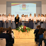 Na scenie chór młodych dziewcząt wraz z kłaniającą się dyrygentką