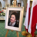 Zdjęcie Karoliny Kaczorowskiej w ramce, po prawej stronie wiszące flagi Polski