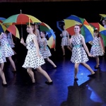 Dziewczynki tańczą z kolorowymi parasolkami