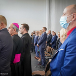 Goście honorowi stoją podczas uroczystości, pomiędzy innymi osobami widać Zastępcę Prezydenta Rafała Rudnickiego