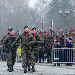 Żołnierze maszerują po placu koło pomnika Marszałka