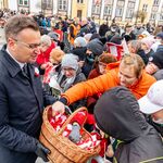 Zastępca prezydenta Rafał Rudnicki rozdaje mieszkańcom kokardy narodowe