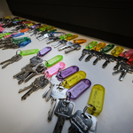 Wiele kluczy z kolorowymi brelokami leży na stole