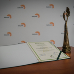 Statuetka Ekolaur oraz dyplom na tle ścianki z logo Białegostoku