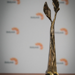 Statuetka Ekolaur na tle ścianki z logo Białegostoku