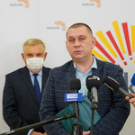 Radny Tomasz Kalinowski przemawia do mikrofonu, za nim stoi Prezydent Miasta