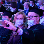 Studenci robią sobie zdjęcie siedząc na widowni