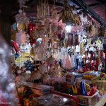 Stoisko z ręcznie wykonanymi zabawkami, aniołkami i dziadkami do orzechów oświetlone białymi świątecznymi światełkami