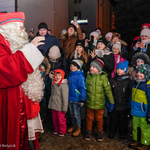 Święty Mikołaj pozdrawiający grupę uśmiechniętych dzieci