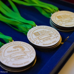 Drewniane grawerowane medale leżące na niebieskim materiale