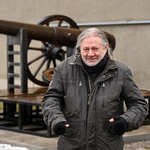 Andrzej Dworakowski stojący na tle swojej instalacji pod tytułem 