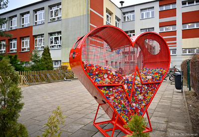 Pojemnik w kształcie serca stojący na placu przed szkołą