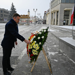 Zastępca prezydenta Rafał Rudnicki poprawia kwiaty przy pomniku
