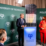 Mężczyzna w garniturze przemawia przy mównicy patrząc na stojącą obok rektor Politechniki Białostockiej