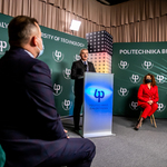 Mężczyzna w średnim wieku za mównicą wypowiada się do mikrofonu