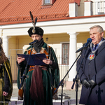 Prezydent Tadeusz Truskolaski przemawia przez mikrofon, po jego lewej stronie stoją prowadzący wydarzenie uczniowie w strojach szlacheckich