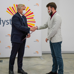Prezydent Tadeusz Truskolaski wręcza stypendium chłopakowi w jasnej marynarce