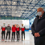 Prezydent Tadeusz Truskolaski stoi na konferencji, w tle olimpijczycy na łyżwach