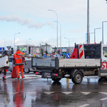 Pracownicy oczyszczają ulicę z barierek