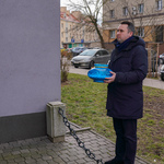 Zastępca prezydenta Przemysław Tuchliński trzyma w ręku znicz