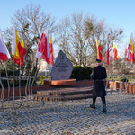 Strażnik miejski stawia znicz przy pomniku ku czci Jadwigi Dziekońskiej ps. „Jadzia” ul. Św. Rocha 14,