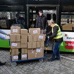 Trzech mężczyzn przygotowuje transport darów do transportu