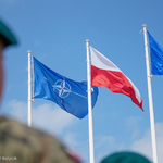 Na wietrze powiewają trzy flagi: Flaga Nato, Flaga Polski i Unii Europejskiej