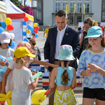 Zastępca prezydenta Przemysław Tuchliński rozdaje mieszkańcom lizaki