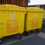 Dwa pojemniki na śmieci w kolorze żółtym