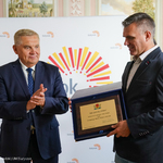 Prezydent Tadeusz Truskolaski. Obok stoi Prezes Tomasz Dąbrowski, który trzyma w dłoniach grawerton