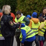 Na zdjęciu widać dzieci rozdające odblaski podczas akcji profilaktycznej